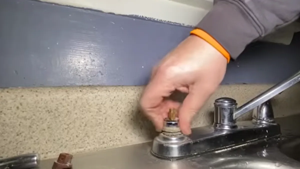 Plumber replacing a kitchen faucet cartridge