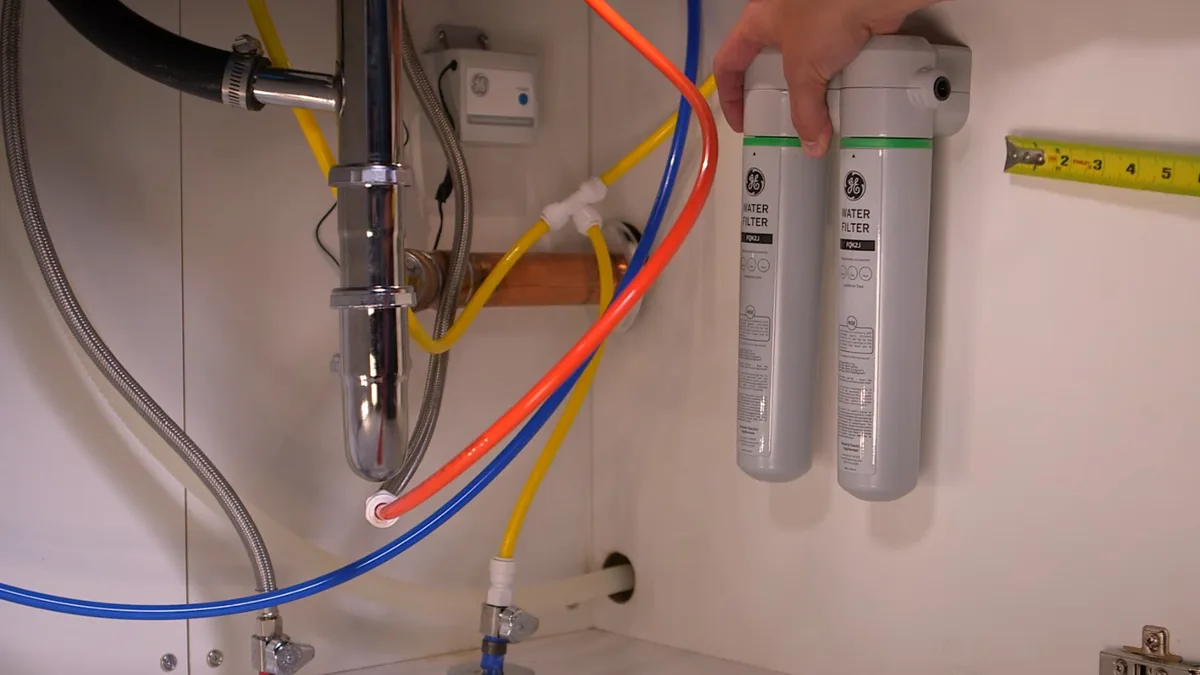 Under-sink water filtration system being installed